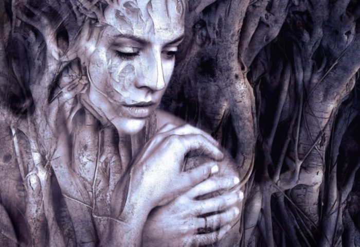 Mujer entrelazada por raíces de árboles.
