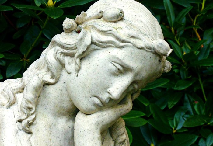 Figura de mujer con rostro de ángel triste.