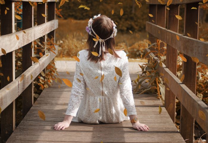 Chica sobre puente, frente a la naturaleza.